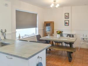 a kitchen with a table and a dining room at Tern House in Amble