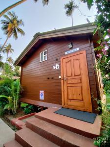 a small building with a wooden door and stairs at Tranquil Beach Resort in Harihareshwar