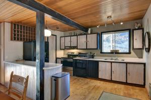 a large kitchen with wooden cabinets and a window at The Woodland Cabin by Instant Suites - Old Village Mont-Tremblant in Mont-Tremblant