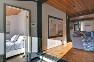 a bedroom with a bed and a couch and a mirror at The Woodland Cabin by Instant Suites - Old Village Mont-Tremblant in Mont-Tremblant