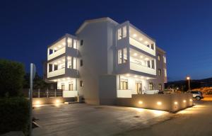 un grande edificio bianco con luci in un parcheggio di Carabella Residence a Città di Lefkada