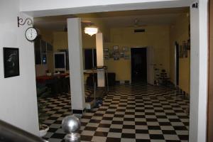 un corridoio con un orologio sul muro e un pavimento a scacchi di "Priyadarshi Villa" Free pickup in ac car from Jasidih Railway station or Deoghar Airport a Deoghar