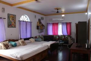 ein Wohnzimmer mit einem großen Bett und einem Sofa in der Unterkunft "Priyadarshi Villa" Free pickup in ac car from Jasidih Railway station or Deoghar Airport in Deoghar
