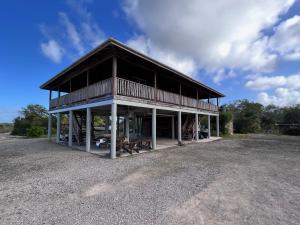 a large building with a deck on a field at Last Frontiers in Gales Point