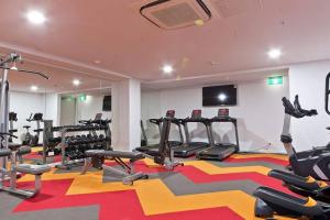ein Fitnessstudio mit mehreren Laufbändern auf einem bunten Teppich in der Unterkunft Four bedroom apartment with facilities in Olympic Park in Sydney