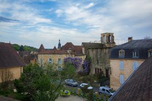 eine Gruppe von Gebäuden in einer Stadt mit geparkten Autos in der Unterkunft Nessmann in Sarlat-la-Canéda