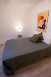 ein Schlafzimmer mit einem großen Bett und einem Gemälde an der Wand in der Unterkunft Nessmann in Sarlat-la-Canéda