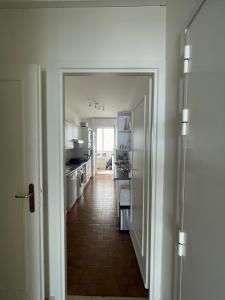 um corredor que conduz a uma cozinha com electrodomésticos brancos em F1 Exclusive 100-sqm Monaco Apartment with Private Parking em Monte Carlo