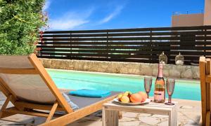 una mesa con una botella de vino y un bol de fruta en Apple Villas, en Mouríon