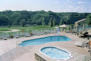 a large swimming pool with chairs and a golf course at Paradise Canyon Golf Resort, Signature Luxury Villa 380 in Lethbridge