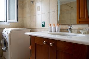 y baño con lavabo y lavadora. en Villa Pasithea, en Korfos