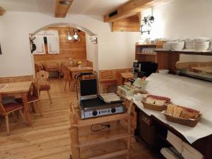 a kitchen with wooden floors and a dining room with tables at Hotel ŠURC in Kranjska Gora