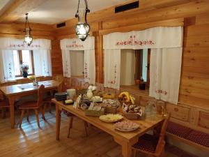 een eetkamer met een tafel met eten erop bij Hotel ŠURC in Kranjska Gora