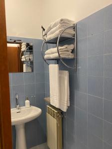 Baño de azulejos azules con lavabo y toallas en YOUR HOME OUTLET 6, en Serravalle Scrivia