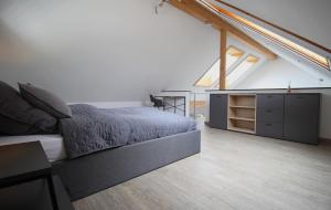 sypialnia z łóżkiem i komodą na poddaszu w obiekcie Hochwertige Maisonette Wohnung - Boardinghouse Gottmadingen w mieście Gottmadingen