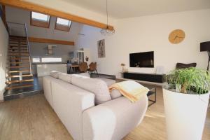 sala de estar con sofá blanco y TV en Hochwertige Maisonette Wohnung - Boardinghouse Gottmadingen, en Gottmadingen