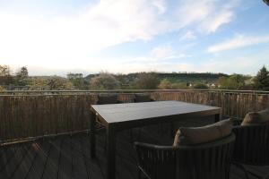 una terraza de madera con mesa y sillas. en Hochwertige Maisonette Wohnung - Boardinghouse Gottmadingen, en Gottmadingen