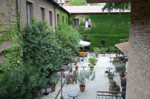 un patio al aire libre con mesas, sillas y plantas en Tiflis Hotel en Tiflis