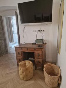 Habitación con escritorio de madera y TV en la pared. en Laetitia en Bastia
