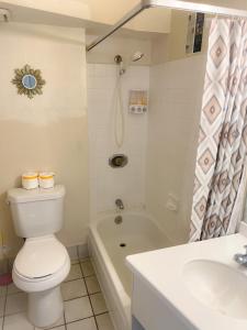 a bathroom with a toilet and a tub and a sink at Hawaiian Monarch 1105 condo in Honolulu