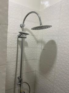 a shower with a shower head in a bathroom at Charmant Studio front de terre Dakar in Dakar