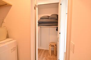 a small closet with a bed on a shelf at Enzo Ikeda A in Omura