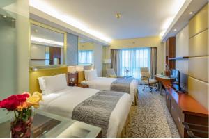 una camera d'albergo con due letti e una televisione di Guo Ji Yi Yuan Hotel a Pechino