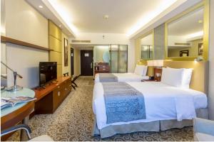een hotelkamer met 2 bedden en een televisie bij Guo Ji Yi Yuan Hotel in Beijing