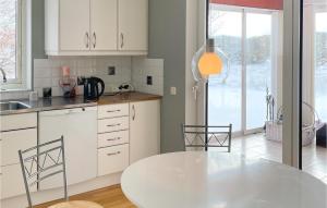 - une cuisine blanche avec une table et des chaises blanches dans l'établissement Lovely Home In Nybrostrand With Kitchen, à Nybro