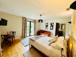 Suite Armagnac, relaxing gite near Nogaro في نوغارو: غرفة نوم بسرير وطاولة واريكة
