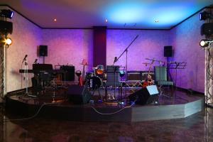 リバティーリゾート大東温泉 في كاكِغو: غرفة أرجوانية بمسرح مع أدوات موسيقية