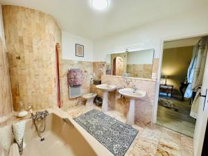 a large bathroom with two sinks and a tub and a tub at Suite Armagnac, relaxing gite near Nogaro in Nogaro +31 photos