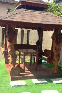 een houten prieel met een tafel in het gras bij 5BR w/ Covered Pool, Jacuzzi, & Gazebo 
