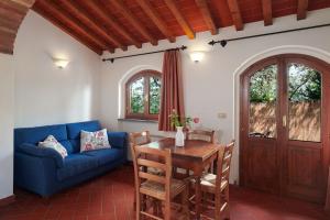 Una sala de estar con un sofá azul y una mesa. en Villa I Leoni, en Montespertoli