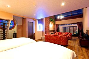 リバティーリゾート大東温泉 في كاكِغو: غرفة نوم مع سرير وغرفة معيشة