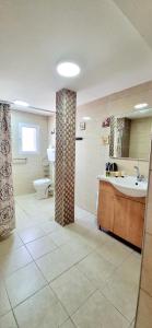 ein Badezimmer mit einer Badewanne, einem Waschbecken und einem WC in der Unterkunft דירת נופש במרכז טבריה in Tiberias