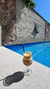 a drink in a glass sitting next to a pool at Aleppo Hotel in Yerevan