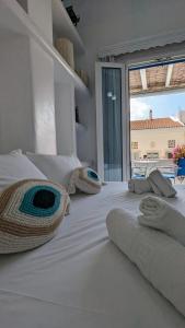 1 cama blanca grande con sábanas blancas y almohadas. en Anoi Rooms en Tinos Town