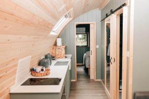 a tiny house with a kitchen with a skylight at Eastfield Glamping Farm in Spennithorne