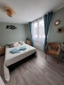 ein Schlafzimmer mit einem Bett, einem Stuhl und einem Fenster in der Unterkunft Maison d'hôtes "At'Home" in Ault