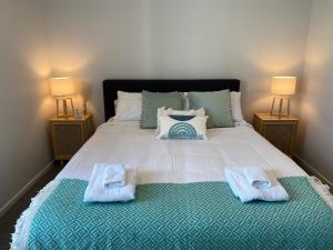 1 dormitorio con 1 cama grande y 2 toallas. en Cityscape, en Christchurch