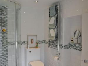 a bathroom with a toilet and a glass shower at The Olde Barn in Dunholme