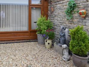 a patio with potted plants next to a building at The Olde Barn in Dunholme