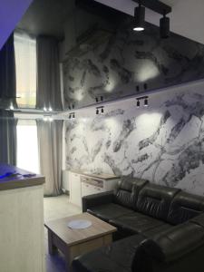 a living room with a couch and a marble wall at IGO-Apartament- 2 sypialnie i Salon in Suwałki