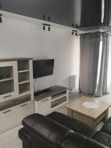 uma sala de estar com um sofá e uma mesa em IGO-Apartament- 2 sypialnie i Salon em Suwałki