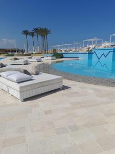uma piscina com duas camas ao lado de uma piscina em Four Seasons Halat em Jbeil