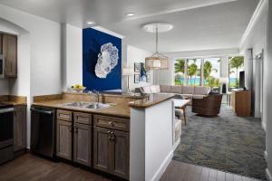 a kitchen with a sink and a living room at Marriott's Ocean Pointe in Palm Beach Shores