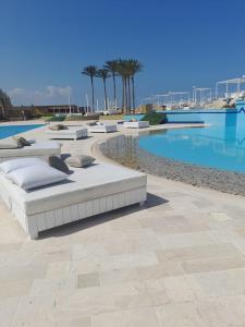 una piscina con 2 camas junto a una piscina en Four Seasons Halat, en Biblos