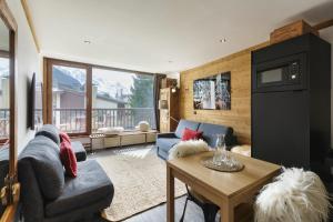 ein Wohnzimmer mit einem Sofa und einem Tisch in der Unterkunft Résidence Coeur d'Argentière 103 Happy Rentals in Chamonix-Mont-Blanc