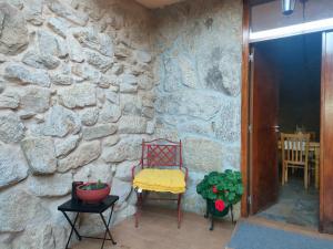a stone wall with a chair and a table at CASA JS in Ourense